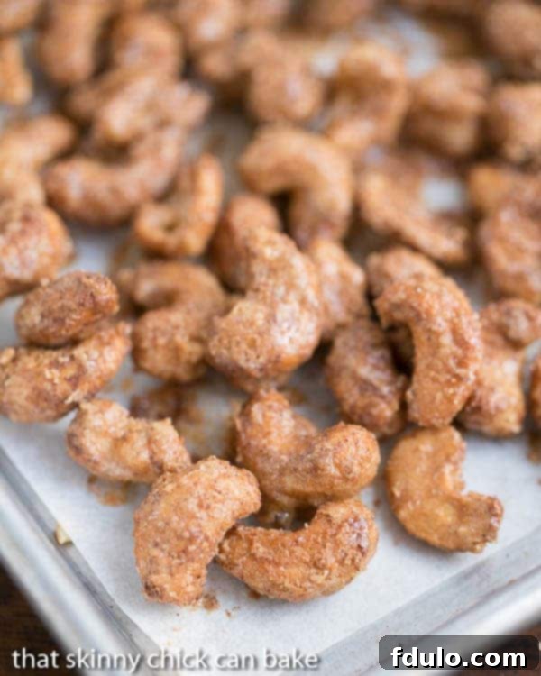 Spicy Sugared Cashews - Sweet, crunchy with a touch of heat! Spicy Sugared Cashews on a parchment lined baking sheet.