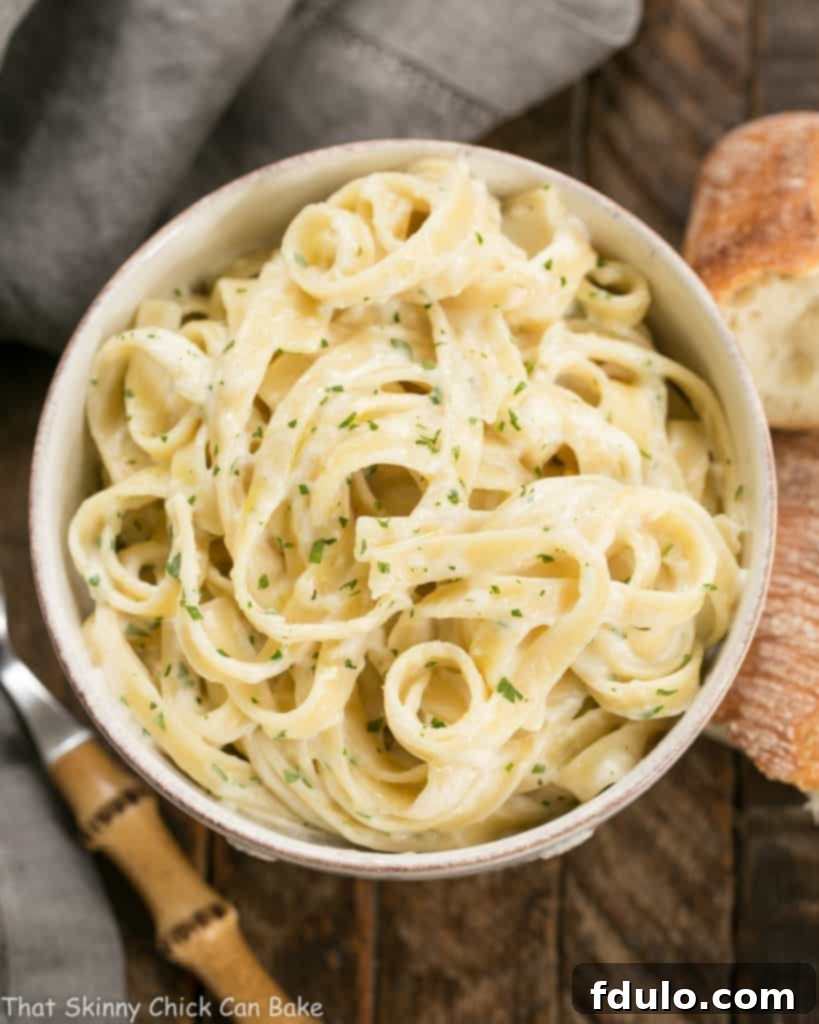 Overhead view of a bowl of Light Fettuccine Alfredo, showcasing its inviting texture and presentation.