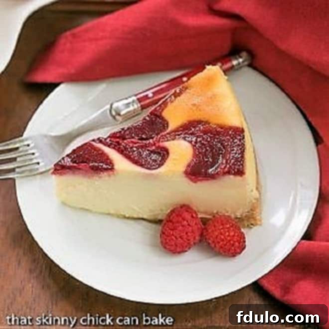 White Chocolate Raspberry Swirl Cheesecake featured image, showing a full cheesecake decorated with fresh raspberries.