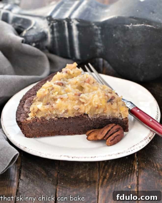 A perfect slice of German Chocolate Brownie Pie on a round white plate, ready to be enjoyed with a red-handled fork.