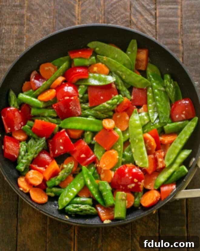 Garlic and ginger sizzling in a wok before vegetables are added.