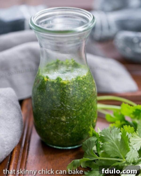 Grilled Flank Steak with Chimichurri Sauce - A fabulous, spicy herb topping for your beef! Close-up of vibrant green Chimichurri Sauce in a glass jar, showing texture.
