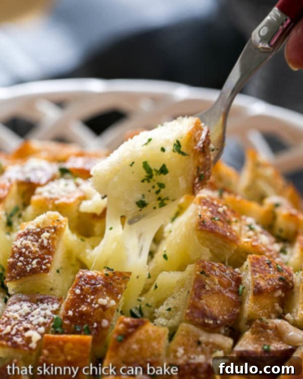 Cheesy Garlic Bread with a fork full of gooey bread on a fork.