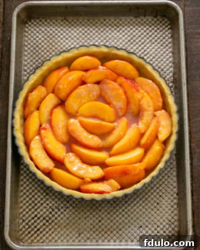 Step 8: Peach slices beautifully arranged in a concentric pattern within the tart shell.