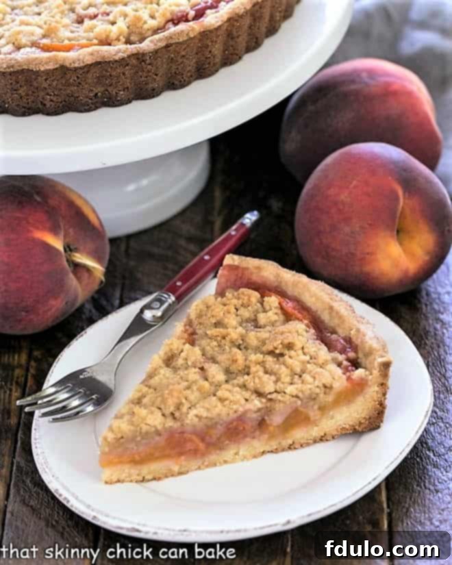 Step 14: A tempting slice of Streusel Topped Peach Tart on a white dessert plate, ready to be enjoyed.
