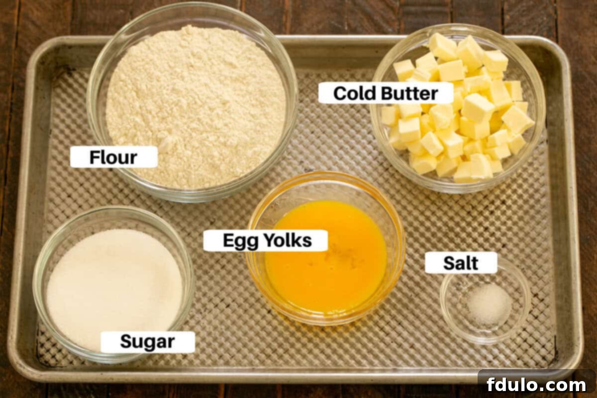 Peach tart crust ingredients with labels on a metal sheetpan, including flour, sugar, salt, cold butter, and egg yolks.