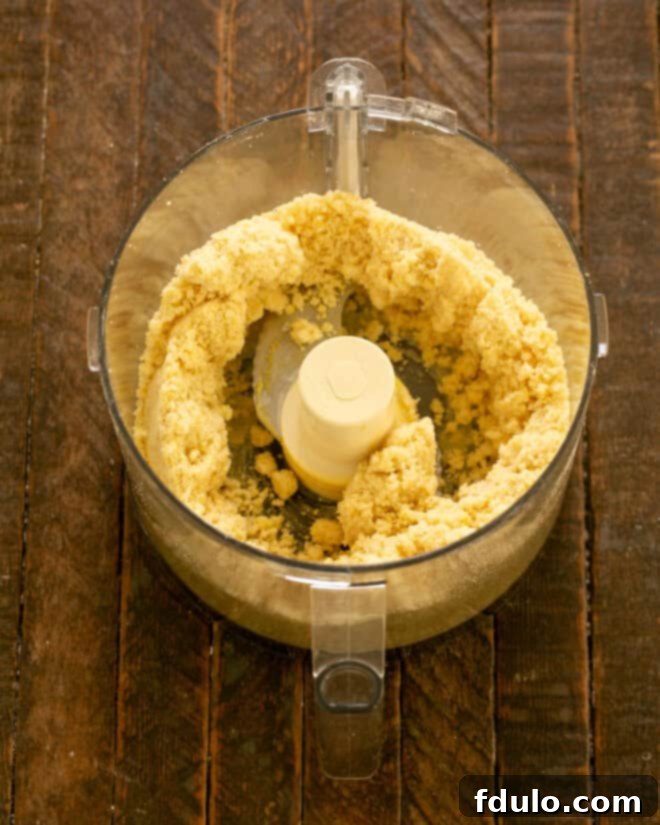 Step 3: Egg yolks added to dough, pulsing until it clumps.