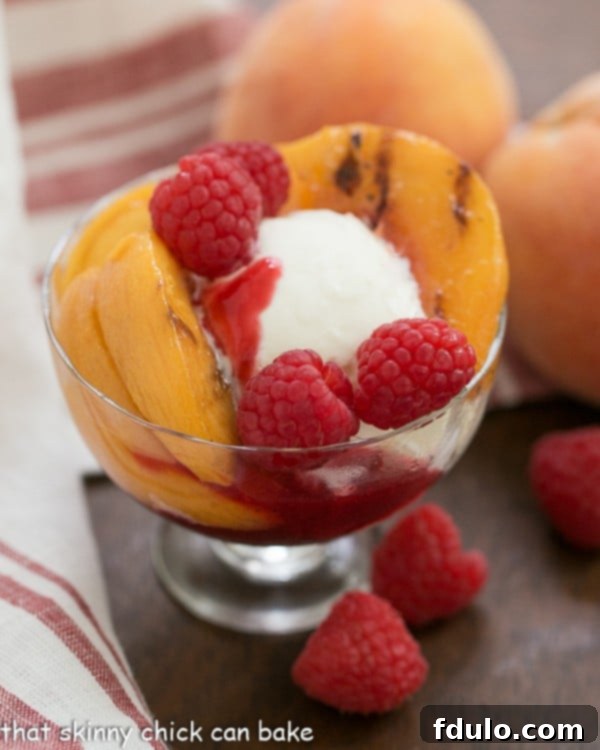 Grilled Peach Melba in a glass dessert dish.