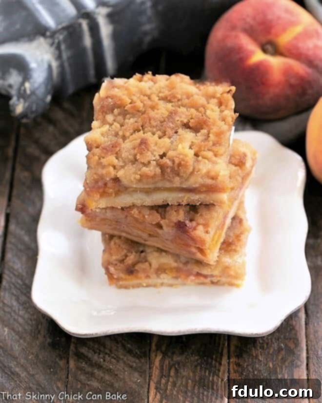 3 peach pie bars stacked on a square white plate, ready to be served