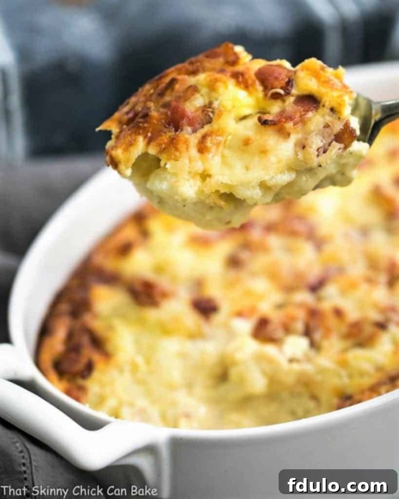 A close-up shot of a spoonful of creamy Cauliflower Gratin with bacon.