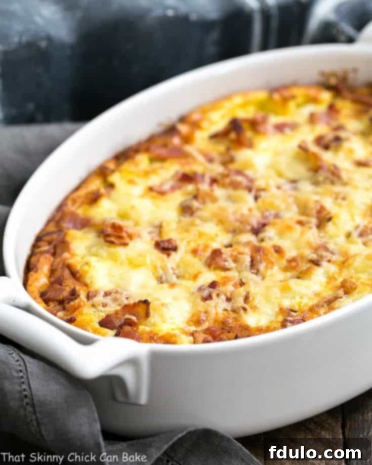 A close up of a cauliflower bacon gratin in a baking dish, golden brown and bubbling.