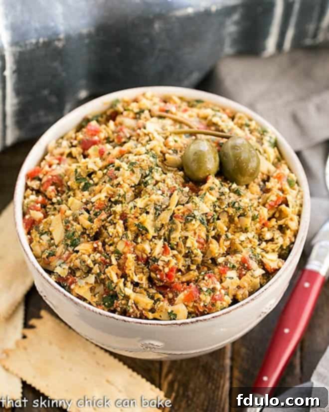 Overhead view of this artichoke tapenade with a red handled spoon
