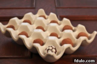 Gourmet chocolate truffles nestled in a rustic ceramic egg crate, ready for gifting or enjoying.
