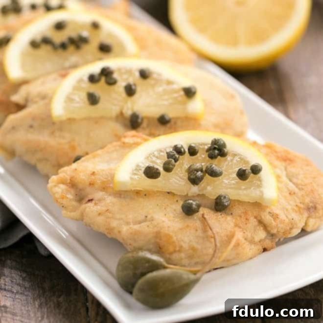 Beloved Chicken Dishes 13 Easy Skillet Chicken Piccata with lemon slices, capers, and a golden sauce, ready to be served.