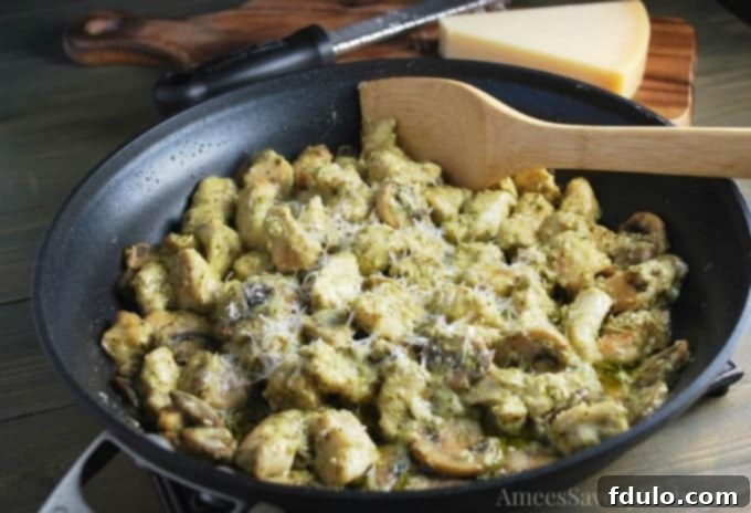Beloved Chicken Dishes 9 Creamy Skillet Pesto Chicken with mushrooms and Parmesan cheese, served directly from the pan.
