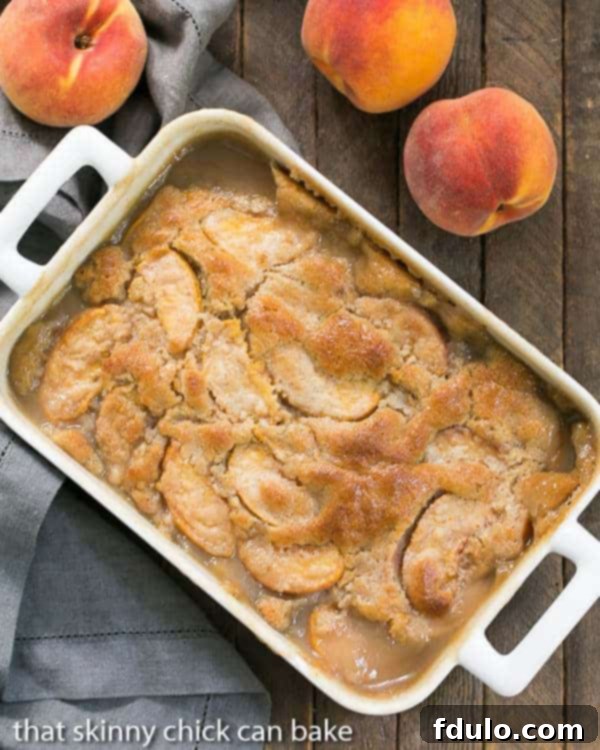 Fresh Peach Pudding - A self saucing peach dessert for a change from crisps and cobblers! Fresh Peach Pudding in a white rectangular casserole dish, garnished with fresh mint.