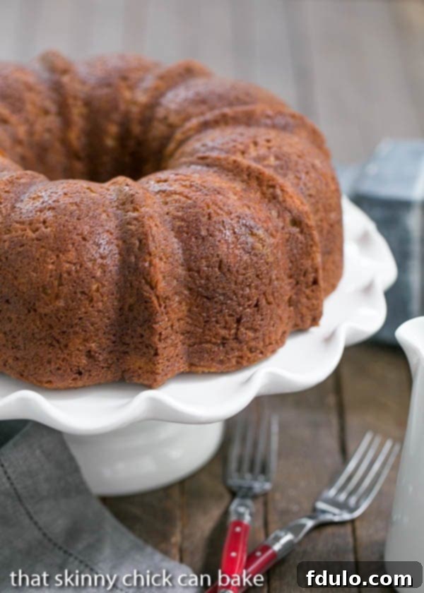 Close-up of a slice of Apple Bundt Cake with a surprise cream cheese filling, showing the moist cake and creamy center.