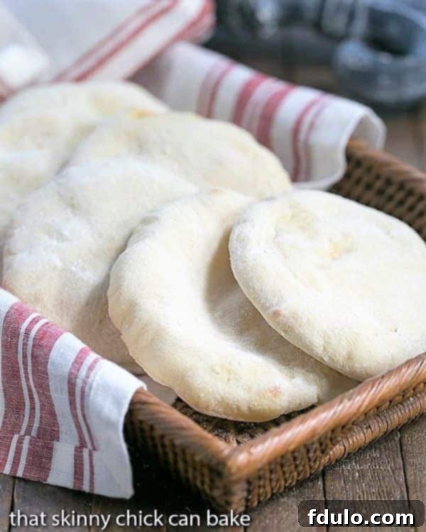 Homemade pocket bread artfully arranged in a wicker basket, featuring a soft, fluffy texture, ready to be enjoyed.