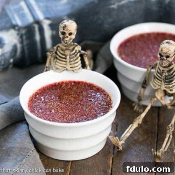 Bloody Crème Brûlée - The classic vanilla custard with burnt sugar topping and a ghoulish twist! Bloody Creme Brulee in elegant white ramekins, showcasing the deep red color.
