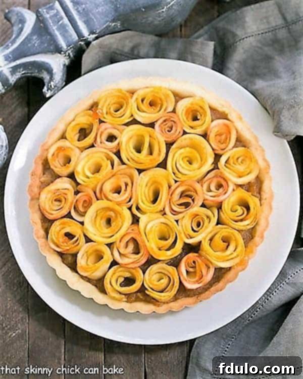 Overhead view of Rose Apple Tart on a white ceramic plate, highlighting the perfectly arranged apple roses.