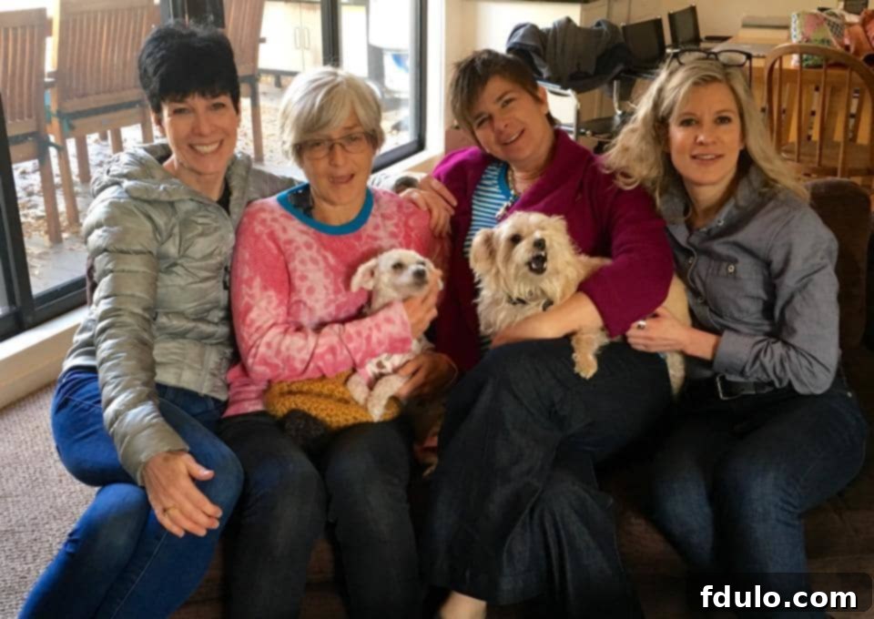 Four sisters, including the author, smiling together in Aspen by the Roaring Fork River, enjoying their reunion.