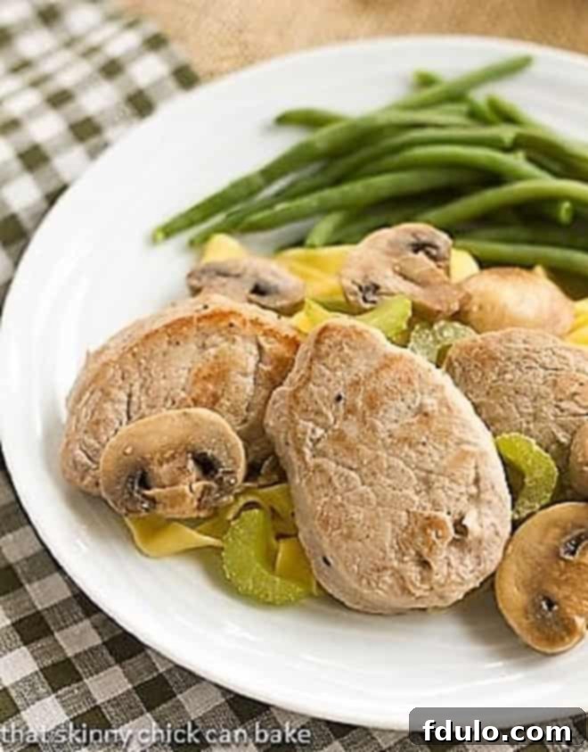 Easy Pork Scaloppine on a white plate with a side of vibrant green beans.
