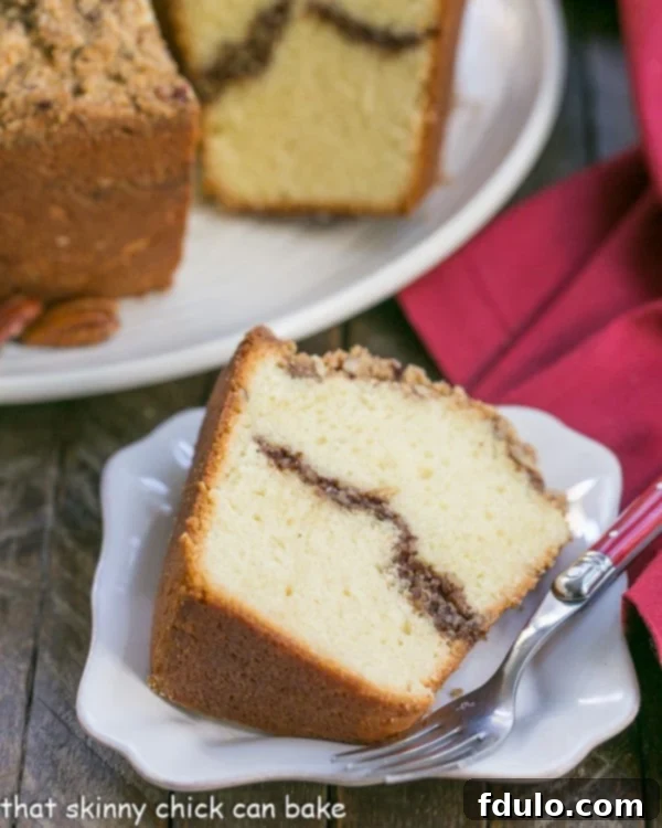 A perfectly portioned slice of Streusel Coffeecake Pound Cake on a square white plate, revealing the intricate ribbon of streusel within.