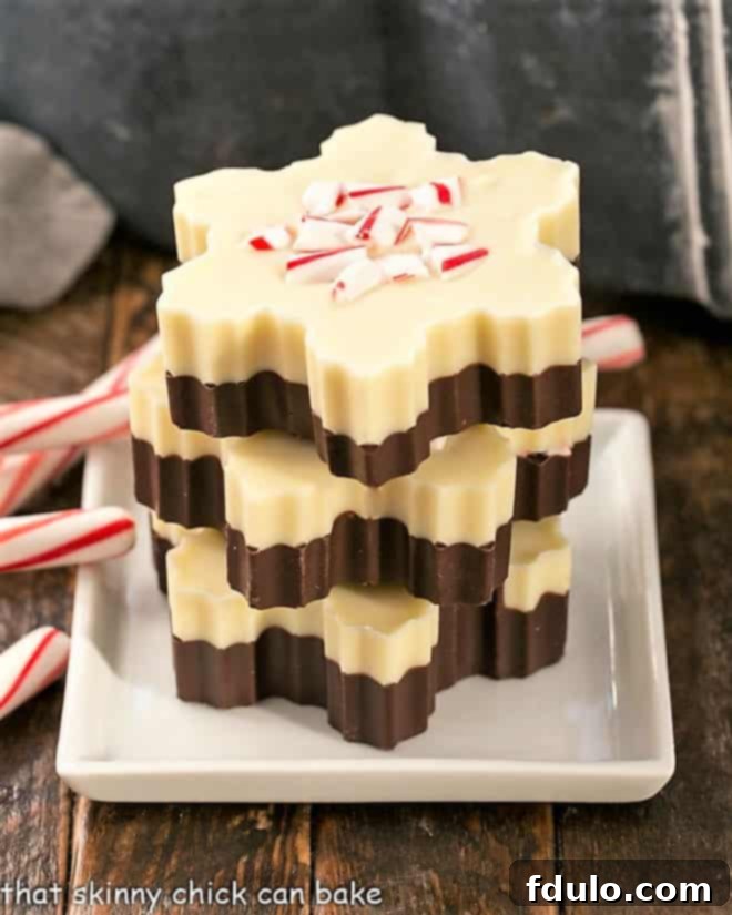 Peppermint Bark Snowflakes - A fabulous, impressive holiday or hostess gift! Festive Peppermint Bark Snowflakes delicately stacked on a pristine white plate, garnished with elegant candy cane shards, ready for holiday gifting or enjoyment.