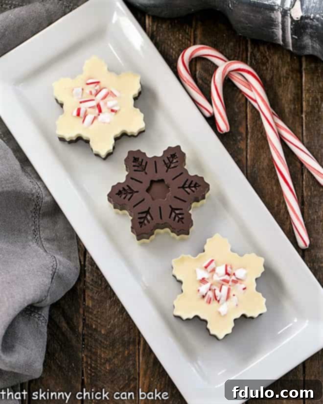 Peppermint Bark Snowflakes - A fabulous, impressive holiday or hostess gift! An overhead view showcasing the front and back of perfectly layered peppermint bark snowflakes, revealing their intricate details and distinct chocolate layers.