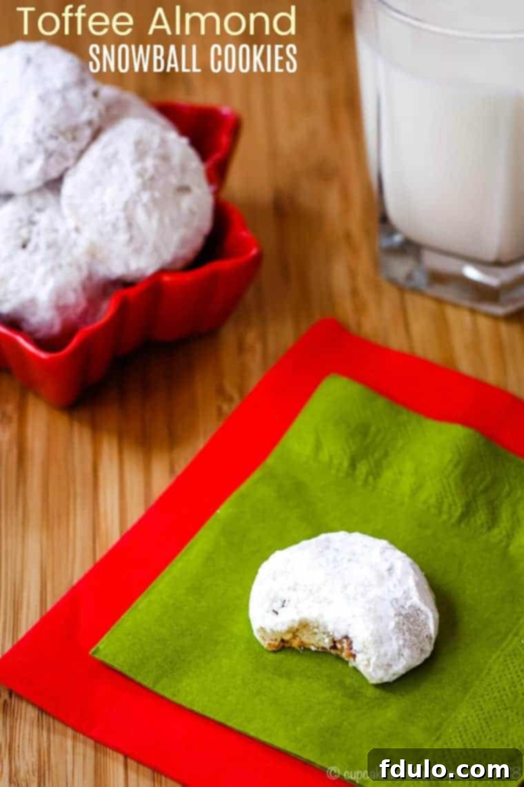 Toffee Almond Snowballs, delicate nutty cookies rolled in powdered sugar, with a hint of crunchy toffee.