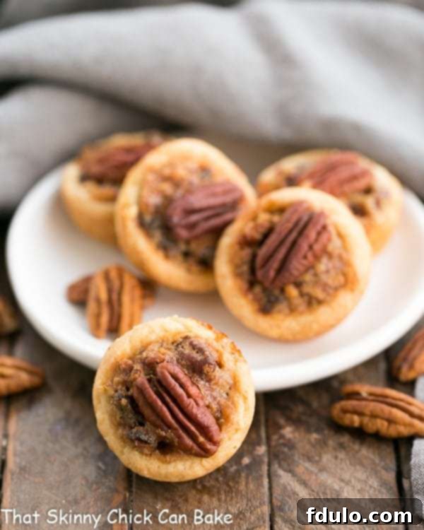 Pecan Tassies Bite-Sized Delights 2 Beautifully baked Pecan Tassies, also known as Mini Pecan Pies, in a delicate cream cheese pastry crust, ready to be enjoyed.