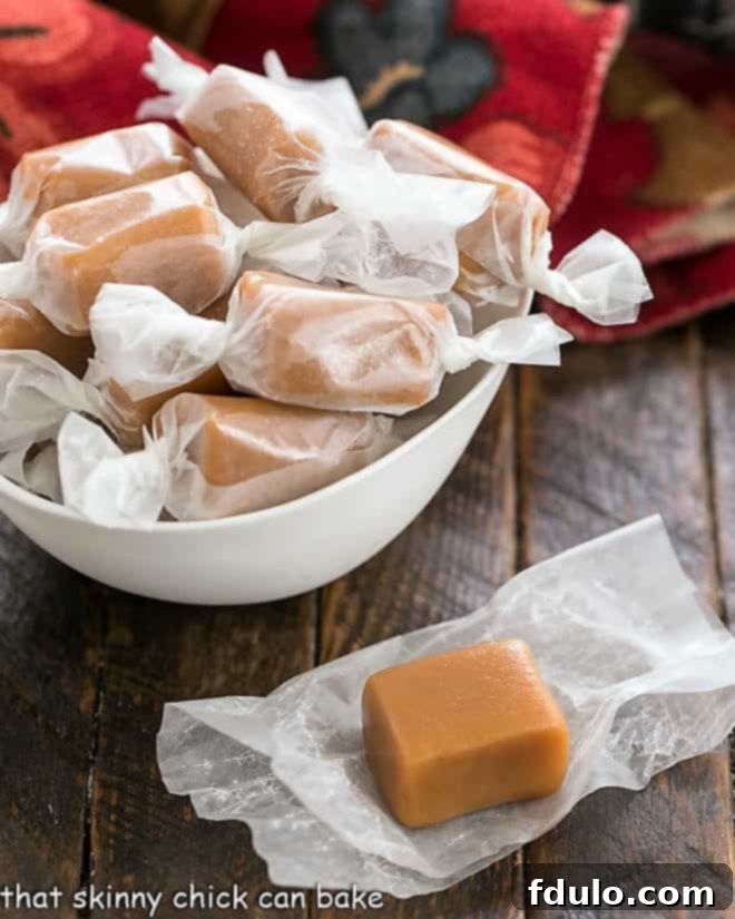 A beautiful white bowl filled with glistening homemade brown sugar caramels, some unwrapped to show their soft, amber interior, inviting a delightful taste.