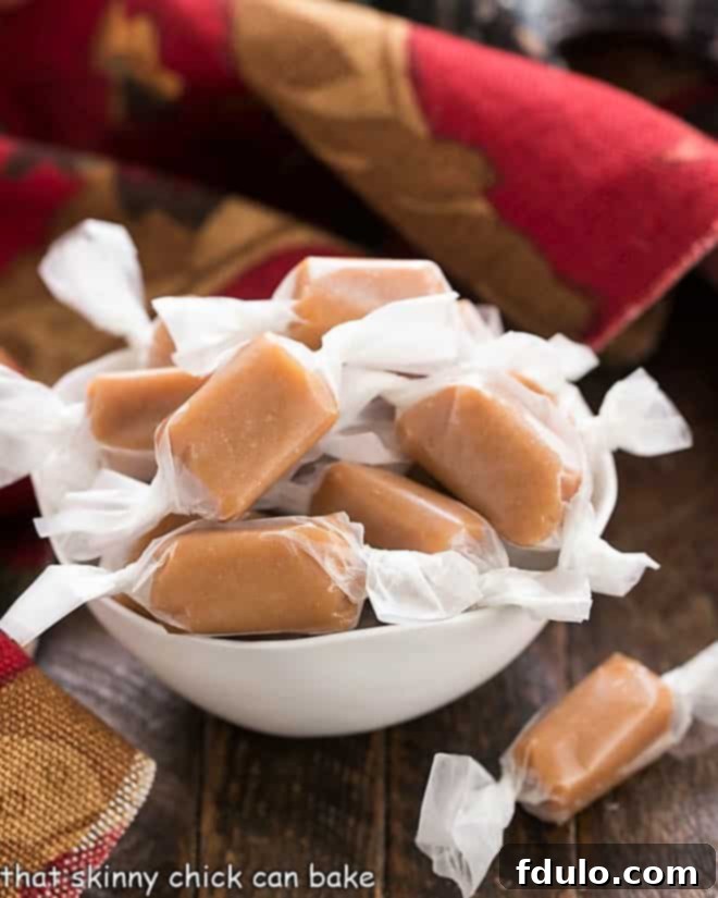 Homemade brown sugar caramels wrapped in wax paper in a white bowl