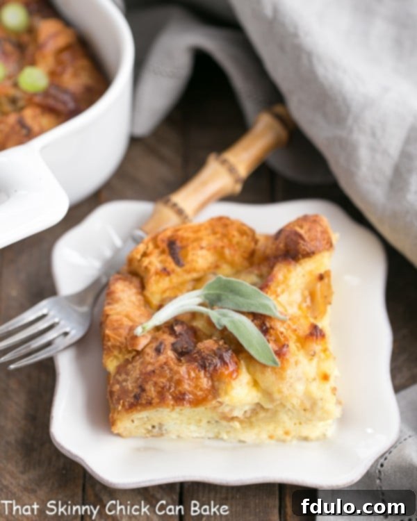 A generous serving of Sausage Croissant French Toast Casserole on a small white plate, showcasing its golden-brown top and savory interior.