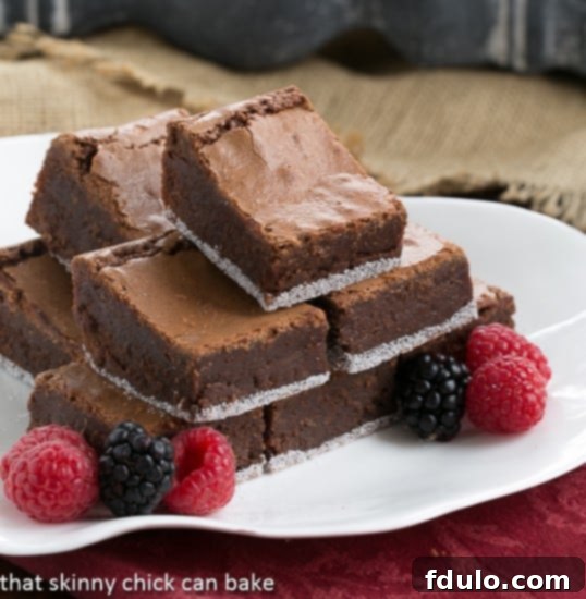 One Bowl Fudgy Brownies on a white serving tray with a berry garnish.