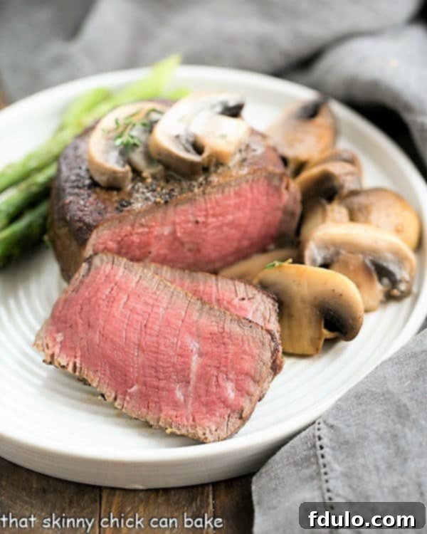 Mushroom Topped Pepper Steak sliced on a white dinner plate.
