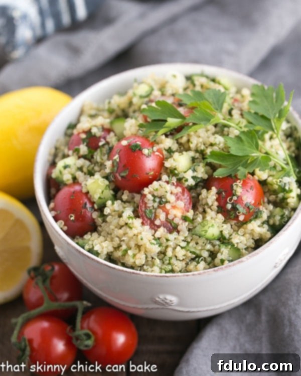 A beautifully presented white bowl of Quinoa Tabbouleh, garnished with fresh herbs, showcasing its vibrant colors and inviting texture. This healthy salad is a perfect side dish or light meal.