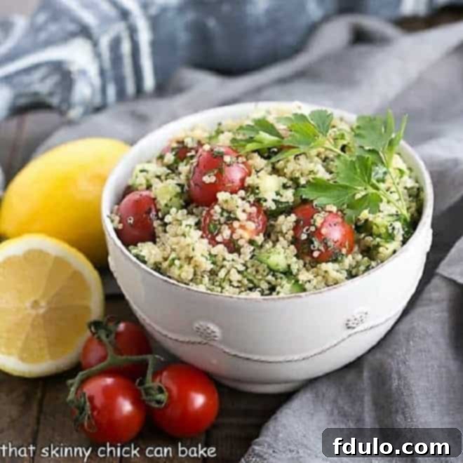 A close-up shot of a white bowl brimming with fresh Quinoa Tabbouleh, elegantly garnished with a whole lemon and vibrant cherry tomatoes, ready to be served as a delightful and healthy meal.