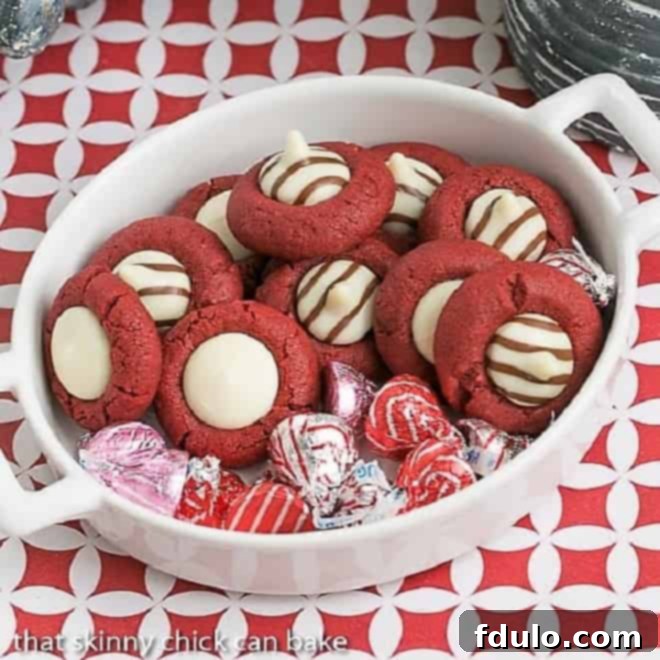 Festive red velvet thumbprint cookies with a white cream cheese filling, perfect for Valentine's Day.