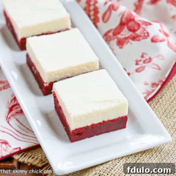 Rich red velvet brownies generously topped with a thick layer of white chocolate icing.