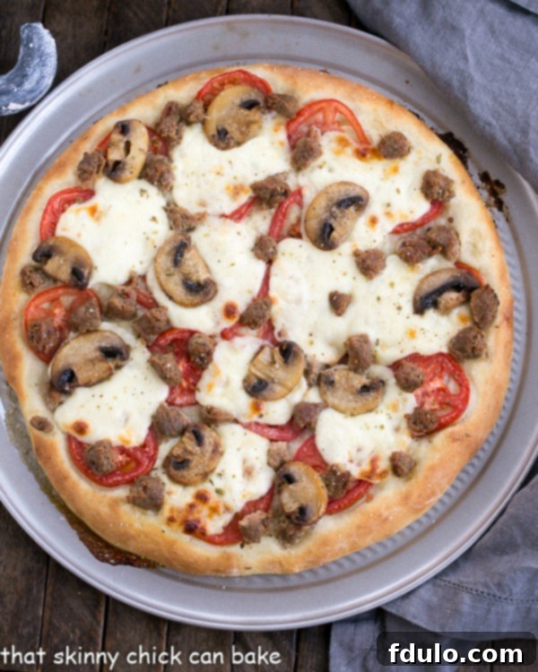 Homemade Sausage Mushroom Pizza - A close-up of the golden crust and bubbling toppings. Overhead view of a perfectly baked Sausage Mushroom Pizza, still hot and inviting.