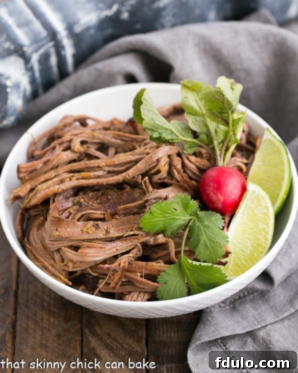 Slow Cooker Carne Asada in a white bowl with a radish and lime wedges