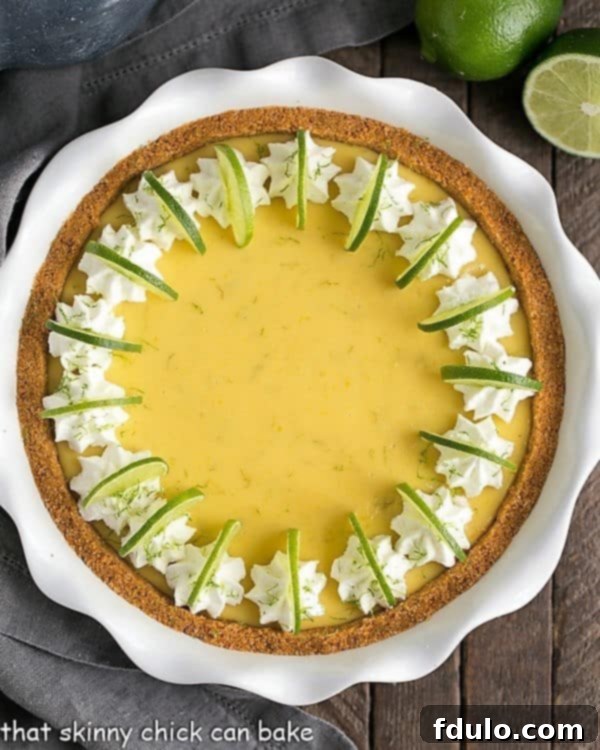 Classic Key Lime Pie with golden Graham Cracker Crust in a white ceramic pie plate, ready to be served.