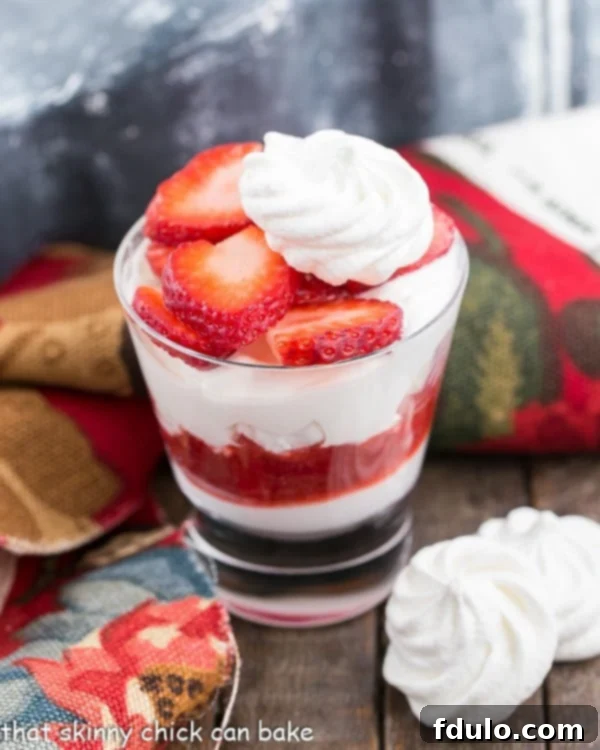Strawberry Eton Mess with Homemade Strawberry Sauce | A blissful dessert with layers of whipped cream, crushed meringues and sliced berries.