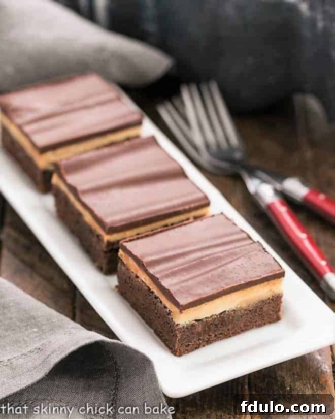 3 Peanut Butter Truffle Brownies on a white ceramic tray, showcasing their decadent layers.