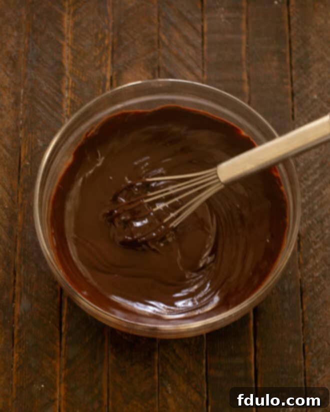 Chocolate ganache being stirred until smooth.