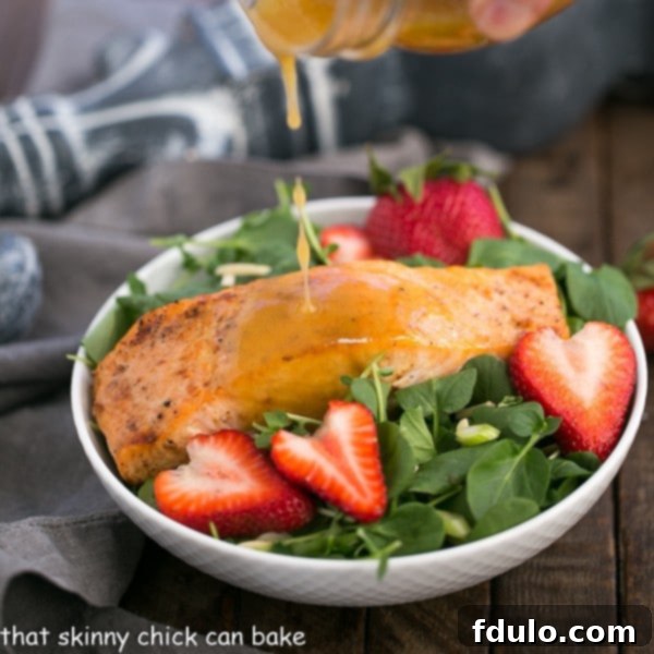 Dressing pouring over a Salmon Watercress Salad in a white salad bowl