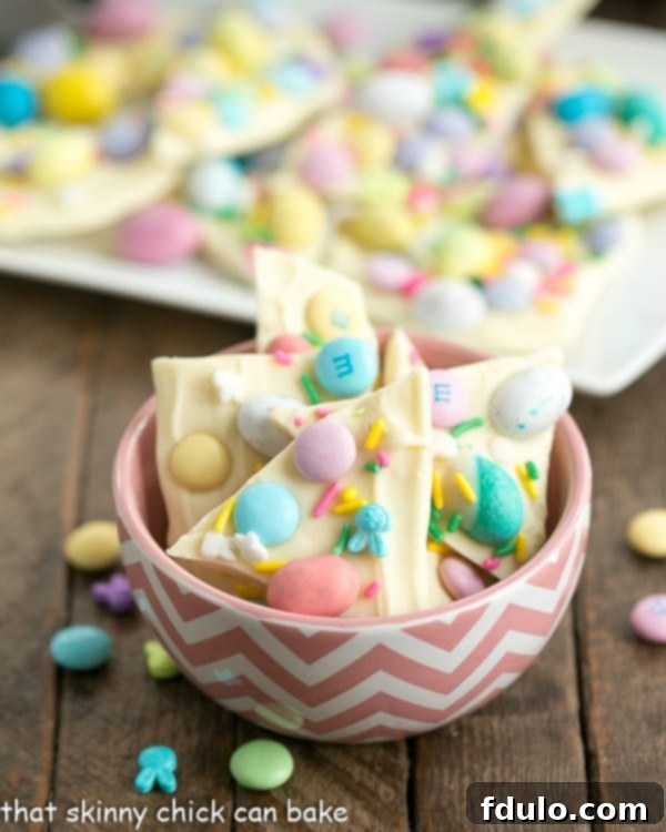 Easy White Chocolate Easter Bark in a pink and white bowl, decorated with pastel candies.