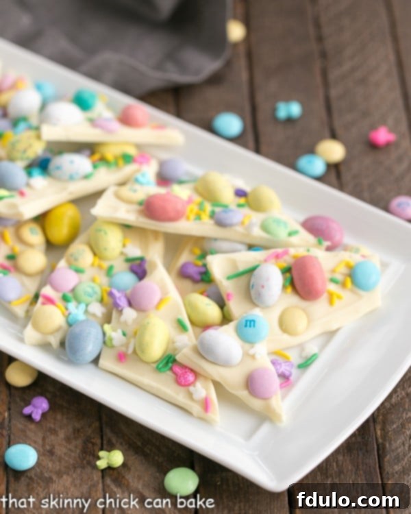 Easy White Chocolate Easter Bark on a white ceramic platter, broken into pieces.