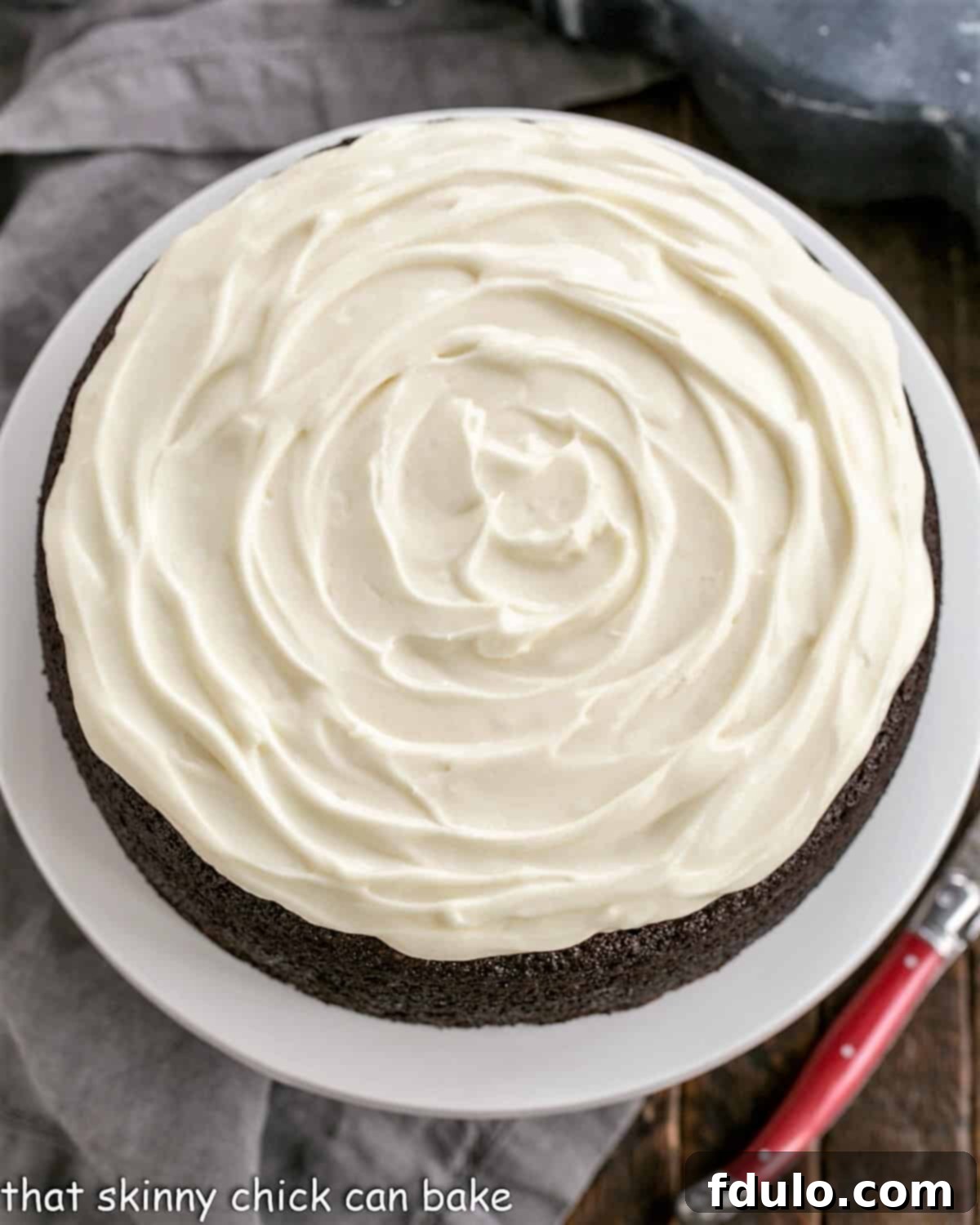 Close-up of a slice of Chocolate Guinness Cake with fluffy cream cheese frosting, showing its moist crumb.